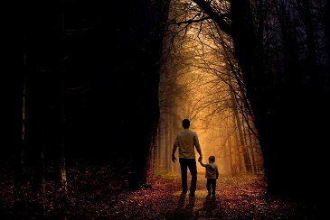 Parent and child walking path through woods